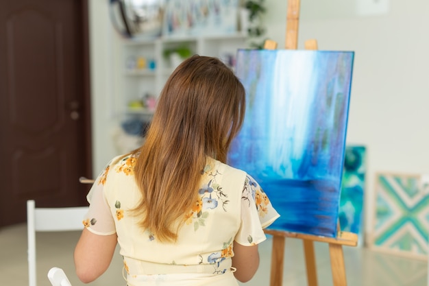 Aula de arte e conceito de desenho - artista mulher trabalhando na pintura em estúdio.