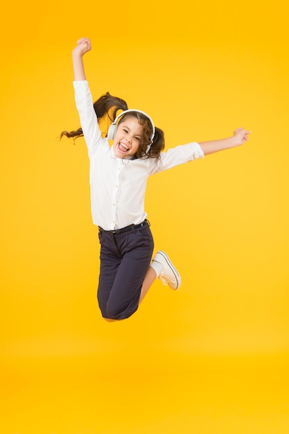 Aula de dança. Fones de ouvido de pupila de menina pequena. Criança feliz ouvir música. Cante canção. Áudio-livro. Conceito de educação e diversão. Escolaridade online. Criança gosta de som de música. Escola de áudio. Educação escolar em casa.