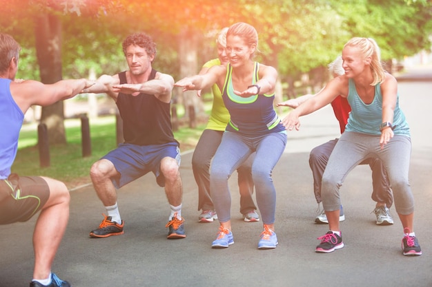 Aula de fitness fazendo sequência de agachamento no parque