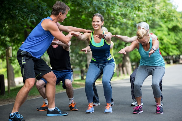 Aula de fitness fazendo sequência de agachamento