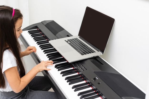 Foto aula de música piano pela internet em casa. estudar online