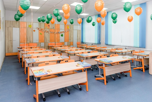 Un aula escolar vacía decorada con globos.