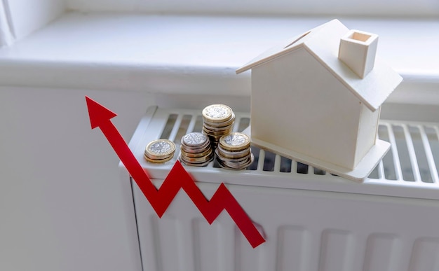 Aumentan las facturas de calefacción del hogar Flecha roja hacia arriba con una casa en un radiador de calefacción
