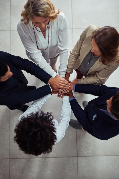 Foto aumentando o apoio para aumentar o sucesso foto de alto ângulo de um grupo de empresários juntando as mãos em unidade