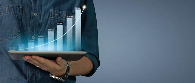 Aumento del crecimiento del gráfico del plan del hombre de negocios de los indicadores positivos del gráfico en la tableta en la mano