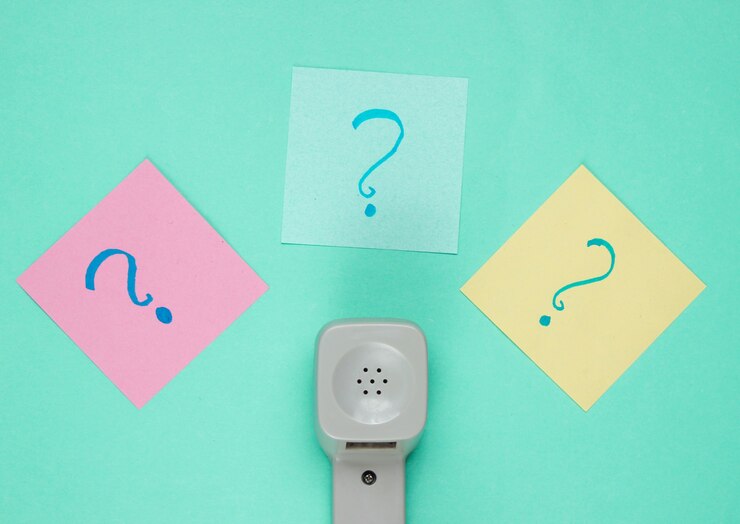 Foto auricular retro y signos de interrogación en trozos de papel de nota