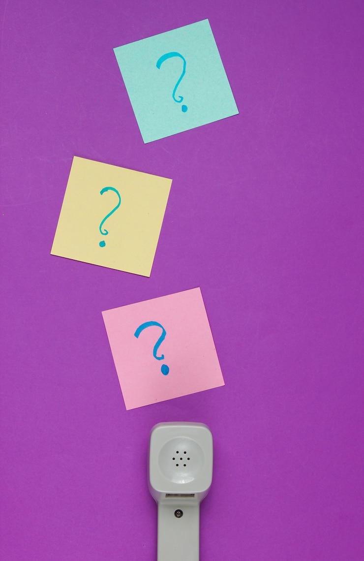 Foto auricular retro y signos de interrogación en trozos de papel de nota