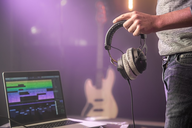 Foto auriculares de audio de estudio para grabar sonido en manos masculinas en el estudio de música