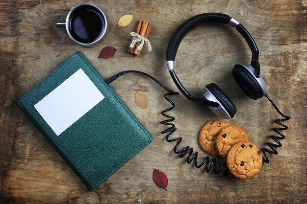 Auriculares audiolibros y libro sobre una mesa de madera