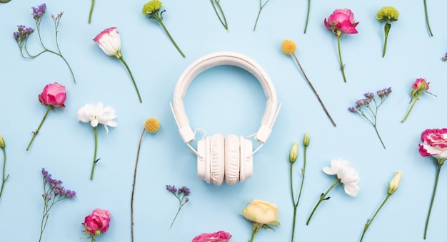 Auriculares blancos sobre un fondo azul y floral