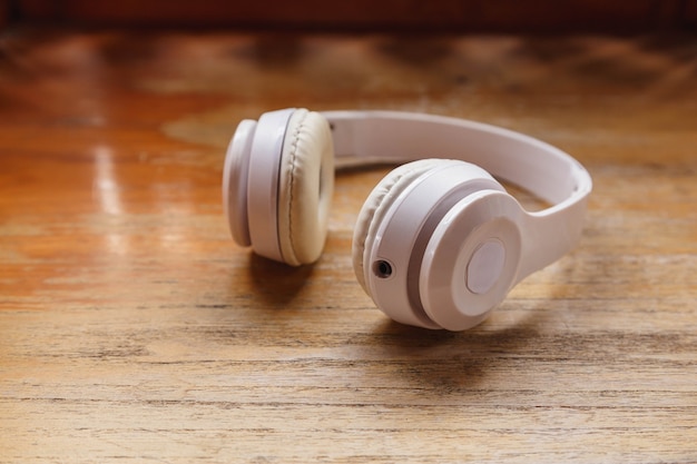 Auriculares blancos sobre superficie de madera. Concepto de música.