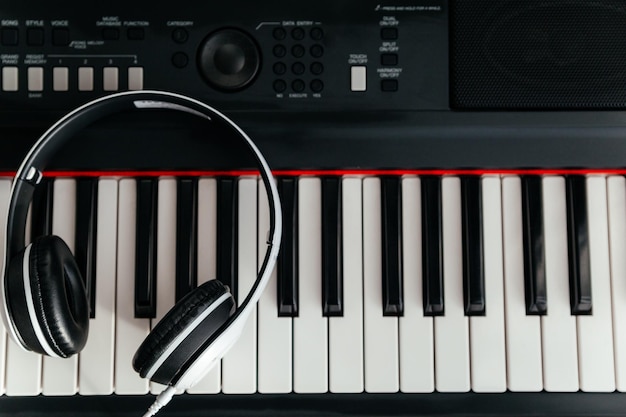 Auriculares blancos en teclado sintetizador musical Auriculares en piano electrónico Vista superior