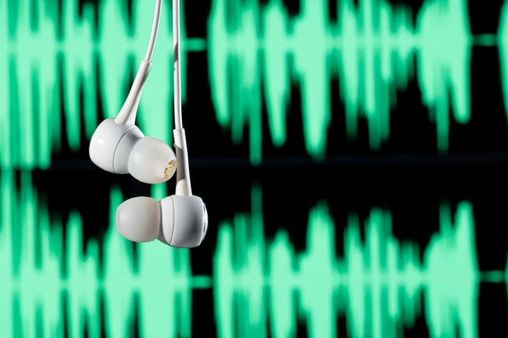 Foto auriculares colgados con ondas sonoras sobre fondo borroso