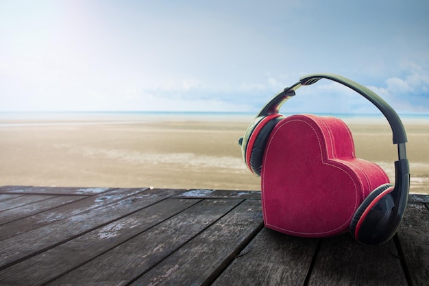 Auriculares con corazón rojo en la playa música de amor retro vintage