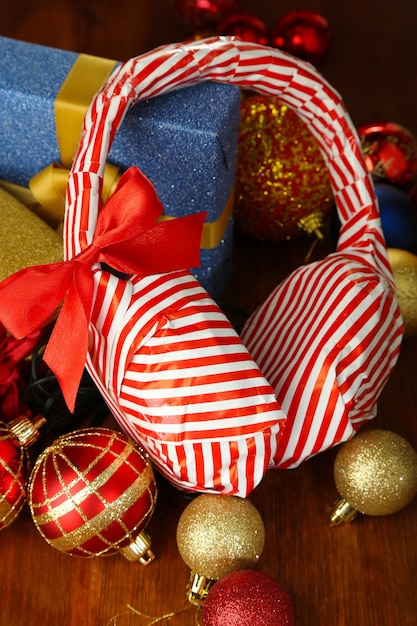 Auriculares embalados en papel de regalo con regalos en primer plano de la mesa de madera