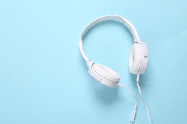 Auriculares estéreo con estilo blanco sobre fondo azul Música minimalista naturaleza muerta amante de la música Vista superior Lay Flat