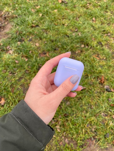 Auriculares inalámbricos en un estuche azul sobre un fondo verde