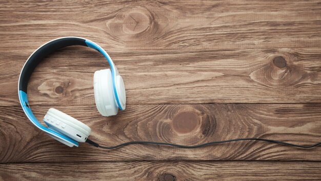 Auriculares inalámbricos en mesa de madera.