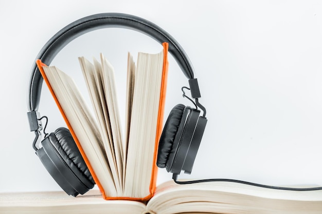 auriculares y un libro sobre un fondo claro