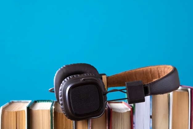 Auriculares y libros pero contra audiolibros azules, escuchando un libro