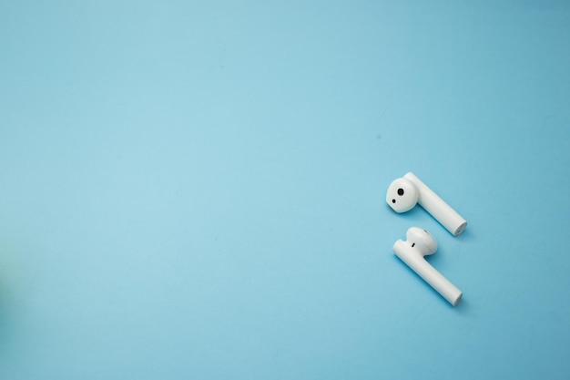 Auriculares musicales brillantes yacen sobre un fondo azul.