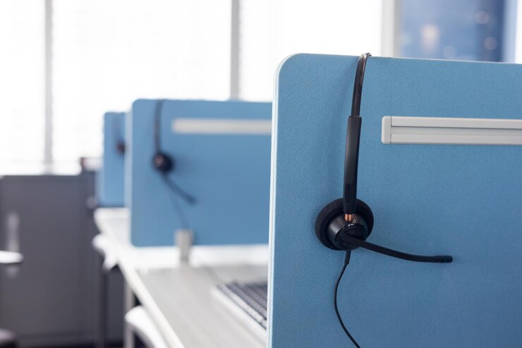 Los auriculares negros para el operador están cuidadosamente almacenados junto al escritorio del centro de llamadas para que los trabajadores trabajen