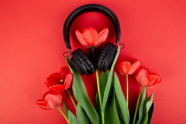 Auriculares negros y ramo de tulipanes rojos