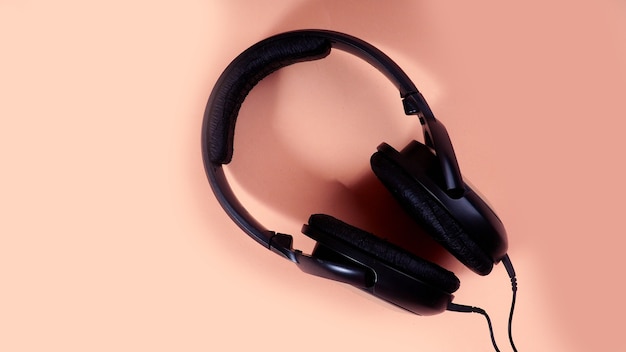 Auriculares negros sobre un fondo uniforme, una copia del espacio de diseño.