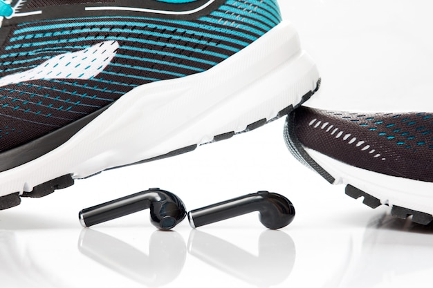 Foto auriculares negros y zapatillas negras para correr