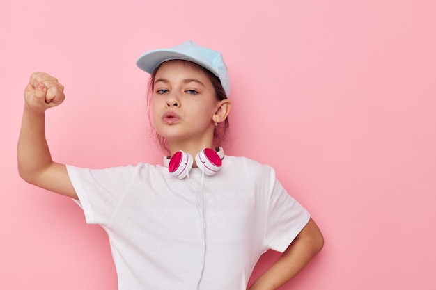 Auriculares de niña bonita con una camiseta blanca y una gorra Estilo de vida inalterado