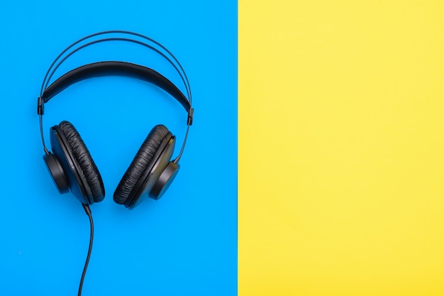 Auriculares profesionales negros con hilo en azul y amarillo.