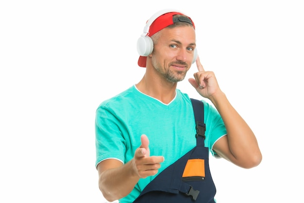 Auriculares que protegen los oídos. Obrero usa auriculares con el dedo acusador. Trabajador escuchar música en auriculares. Audífonos inalámbricos. Nueva tecnología. Música para el trabajo.