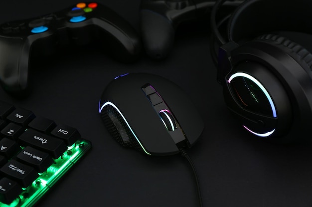 Auriculares de ratón de computadora teclado RGB y controladores de juegos en primer plano de fondo negro