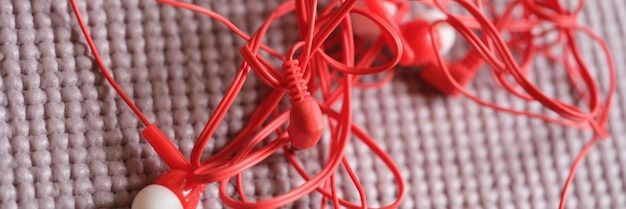 Auriculares rojos enredados sobre fondo gris equipo de audio desordenado para sonido moderno