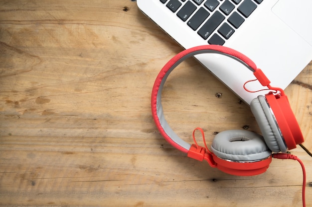 Auriculares rojos en la mesa de madera.