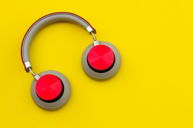 Foto auriculares rojos sobre fondo amarillo. concepto de la música
