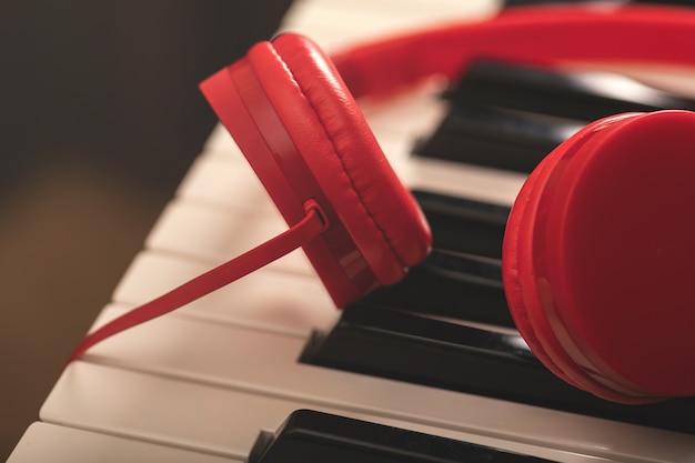 Auriculares rojos sobre teclado sintetizador