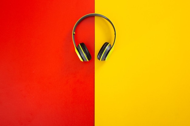 Auriculares sobre fondo rojo y amarillo.