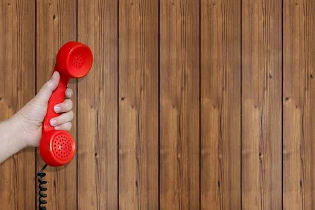 Foto auriculares de teléfono rojos con fondo de madera