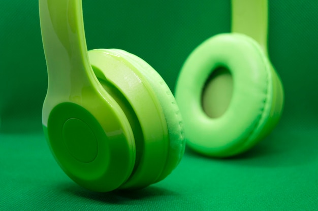 Auriculares verdes aislados de fondo verde