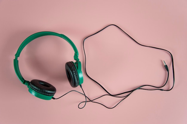 auriculares verdes sobre fondo rosa