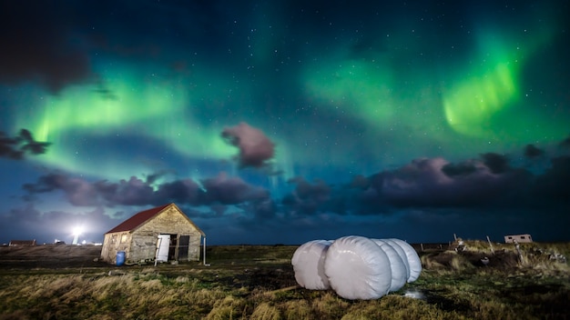 Foto aurora boreal (aurora boreal) sobre casa de campo