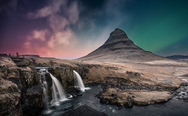 Aurora boreal aurora boreal sobre la cascada de kirkjufell en islandia