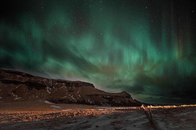 Aurora boreal en el cielo nocturno sobre Reykjavik Islandia con estrellas parpadeantes en el fondo