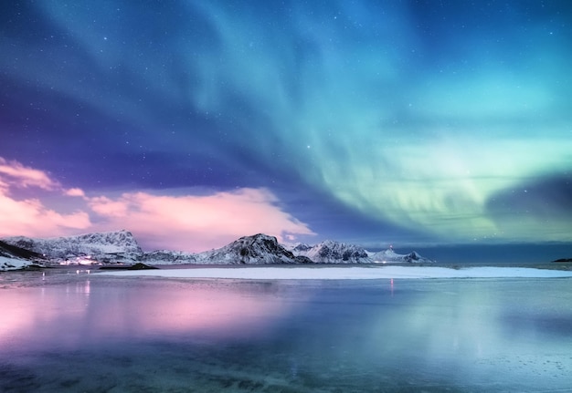 Aurora boreal en las islas Lofoten Noruega Luces verdes del norte sobre el océano Cielo nocturno con luces polares Paisaje nocturno de invierno con aurora y reflejo en la superficie del agua Norwayimage