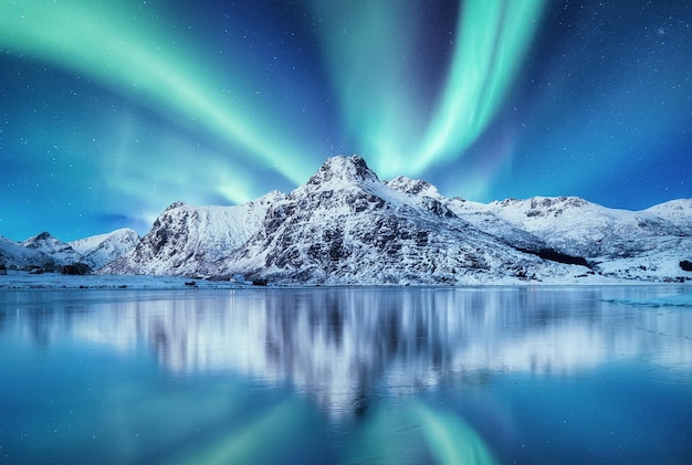 Aurora Boreal Islas Lofoten Noruega Nothen luz y reflejo en la superficie del lago Paisaje invernal en la noche Imagen de viaje de Noruega
