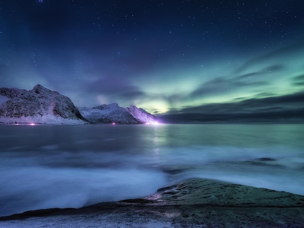 Aurora boreal nas ilhas Lofoten Noruega Verde aurora boreal acima das montanhas Paisagem noturna de inverno com aurora Fundo natural na Noruega