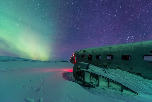 Aurora boreal sobre destroços de avião na Islândia