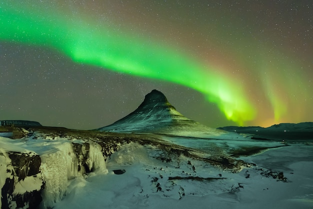 Aurora boreal sobre las montañas en el norte de Islandia en invierno