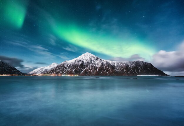 Aurora borealis ilhas lofoten noruega nothen montanhas leves e oceano paisagem de inverno à noite imagem de viagem da noruega